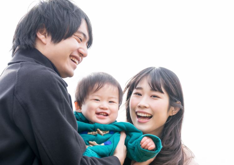 若い夫婦と子供の笑顔の写真
